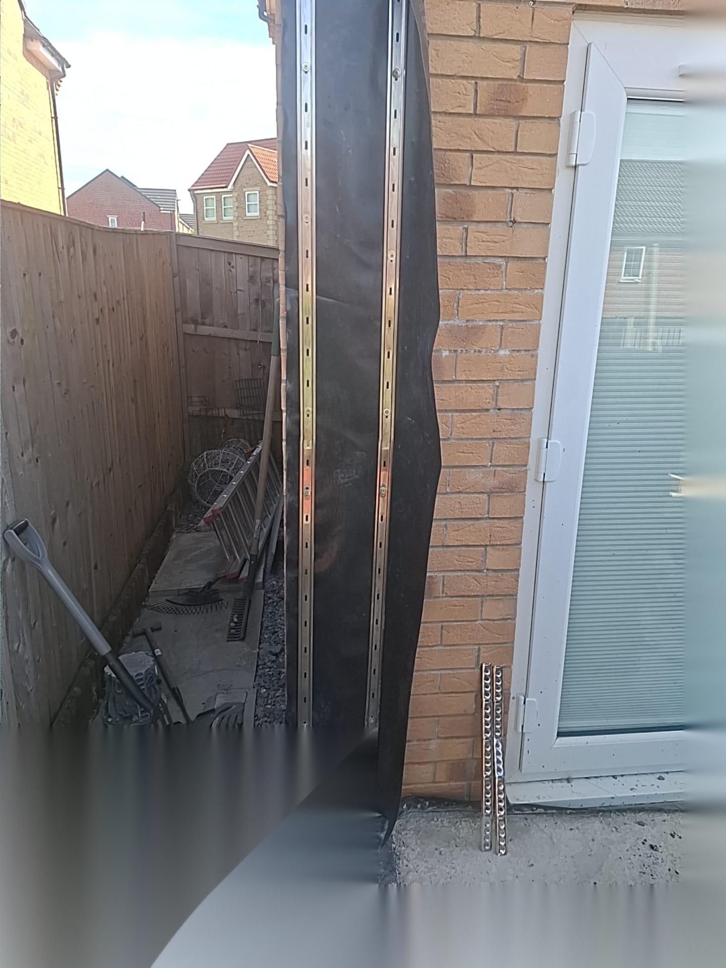 Temporary steel support and flashing detail beside brickwork and a doorway during structural alterations