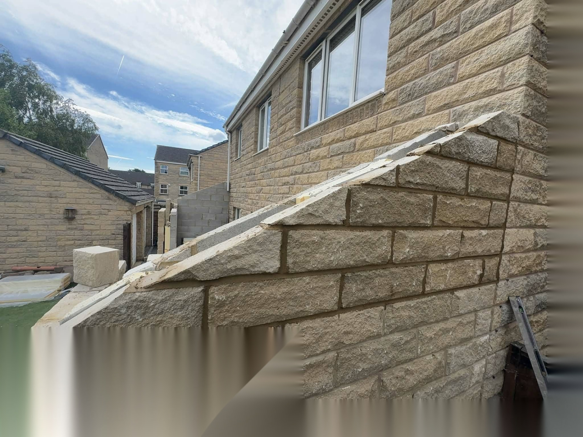Stone extension gable being built up to match the coursed stonework of the existing property