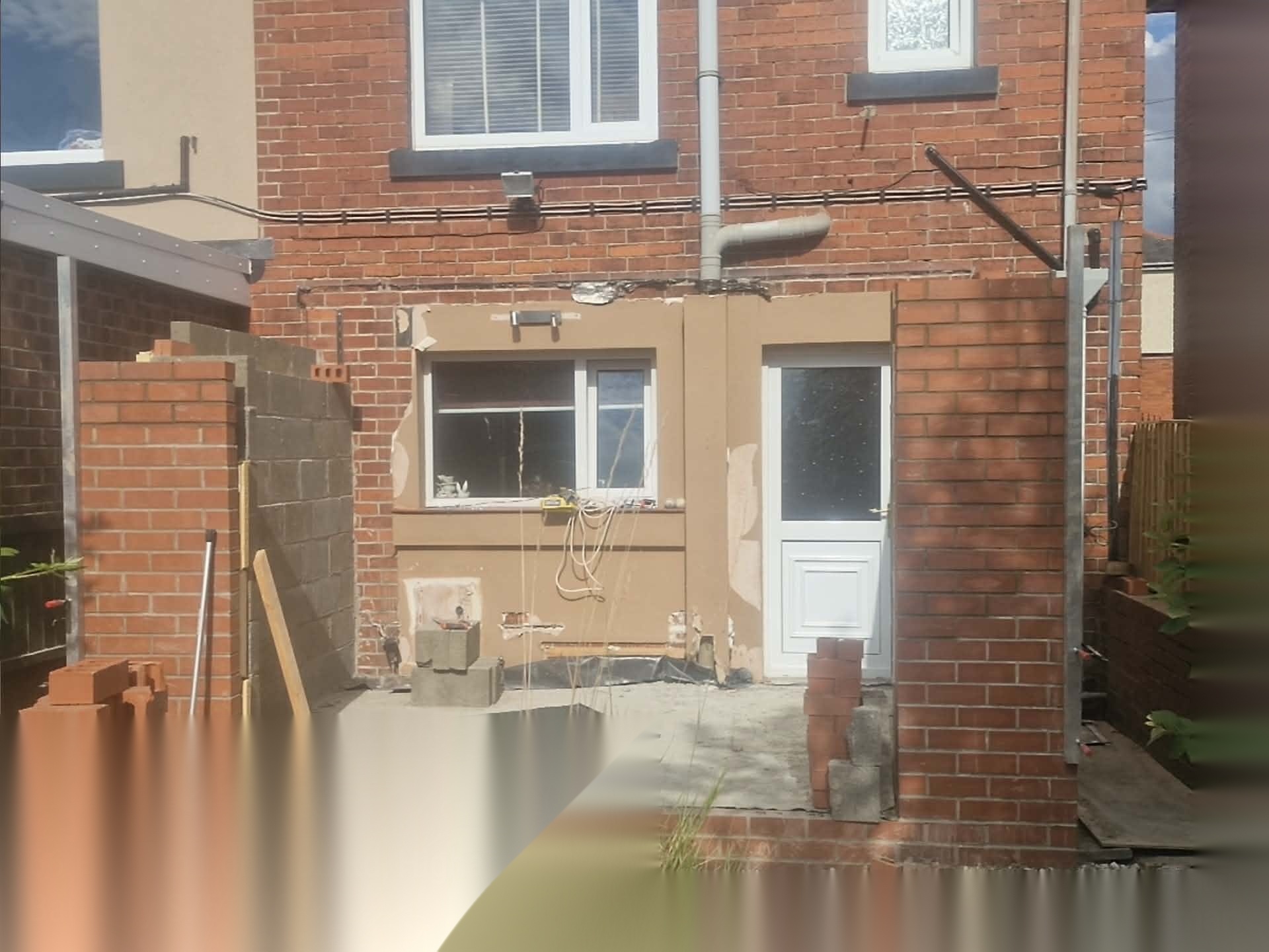 House elevation opened up during extension brickwork, with new openings formed and brickwork in progress