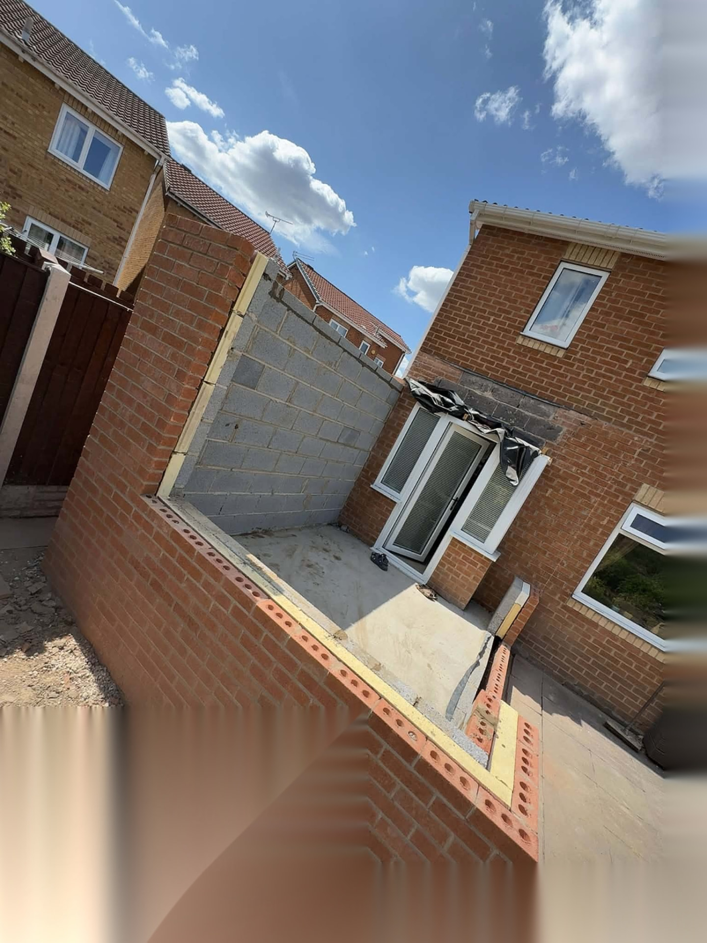 Courtyard extension under construction with brick and block perimeter walls built to damp course level