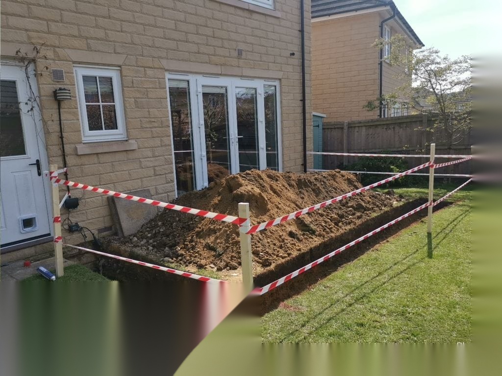 Large foundation excavation taped off beside a house during extension groundworks in South Yorkshire