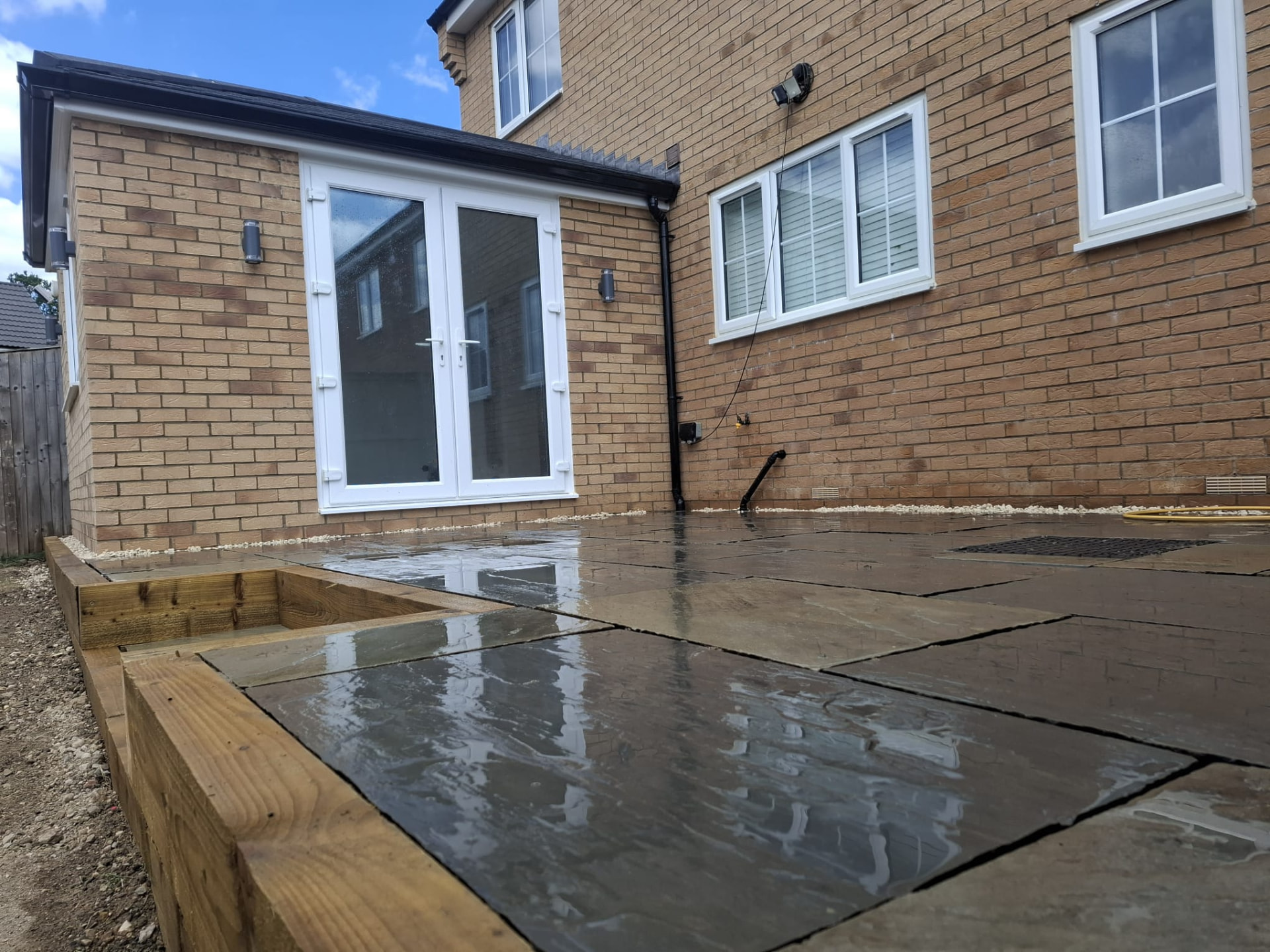 Finished sandstone patio draining cleanly after rain on a South Yorkshire landscaping project
