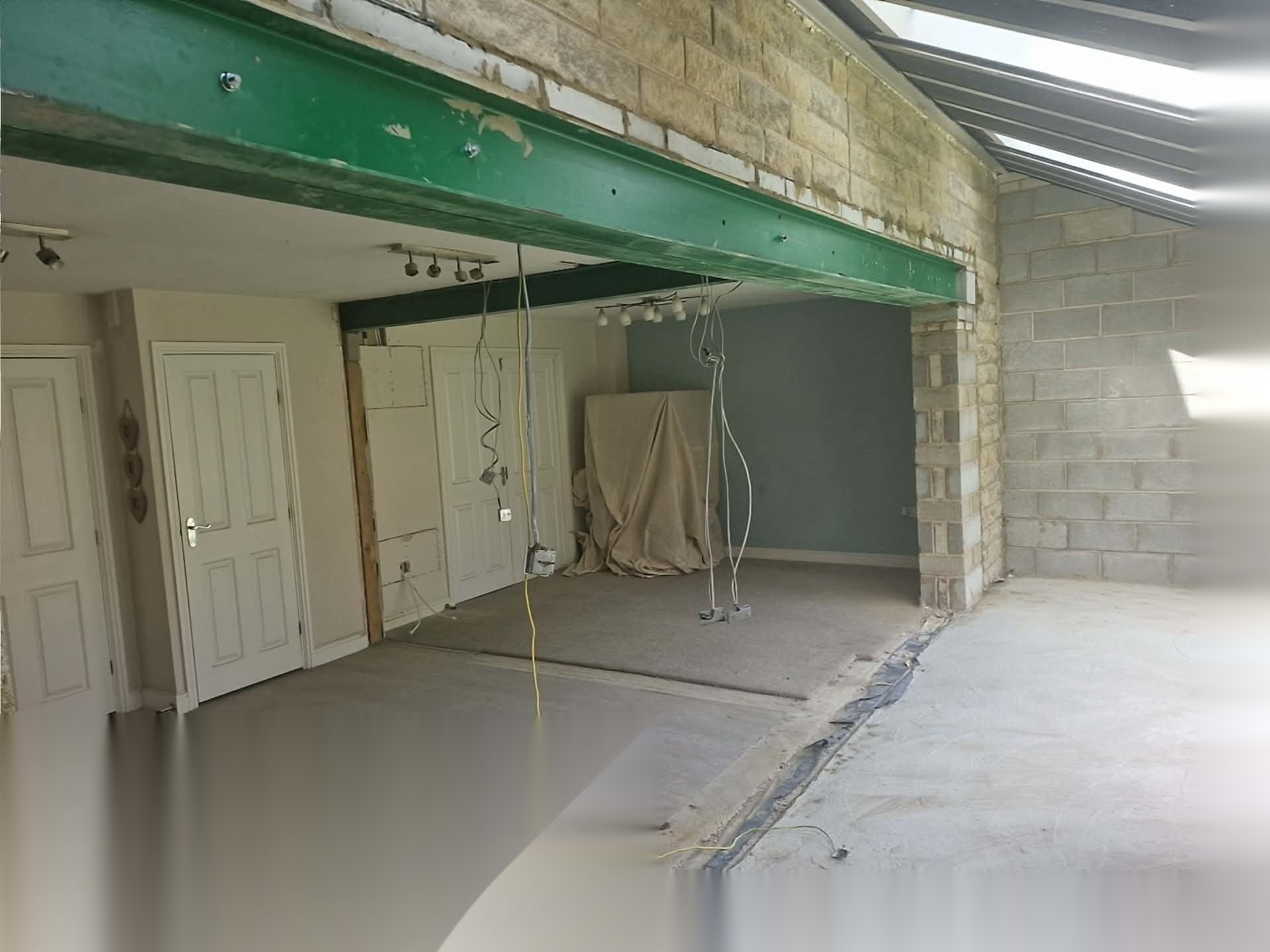Structural steel beam installed over a new opening with blockwork built up around it during an extension build