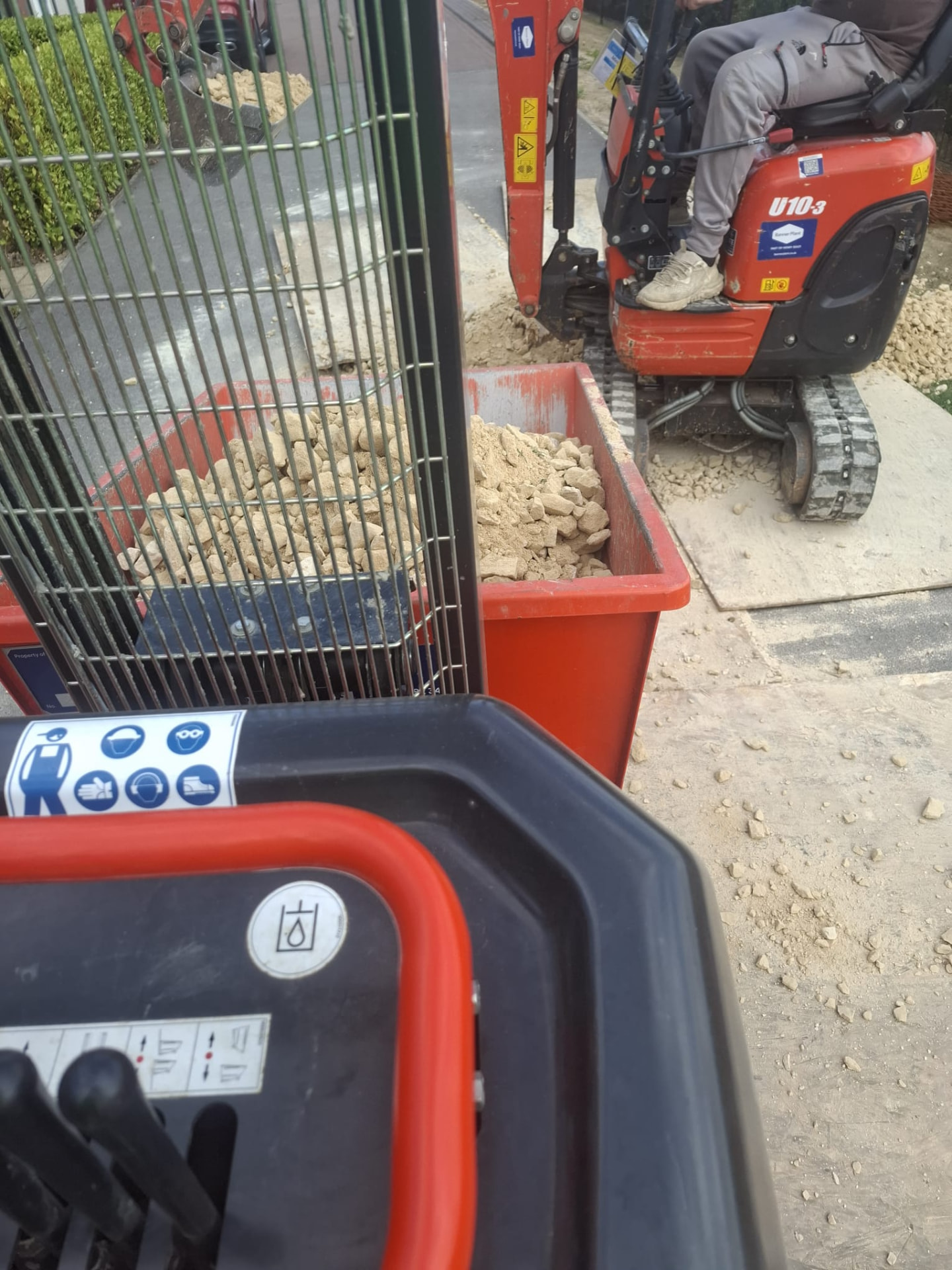 Mini excavator and material handling plant working in a tight access area during groundworks